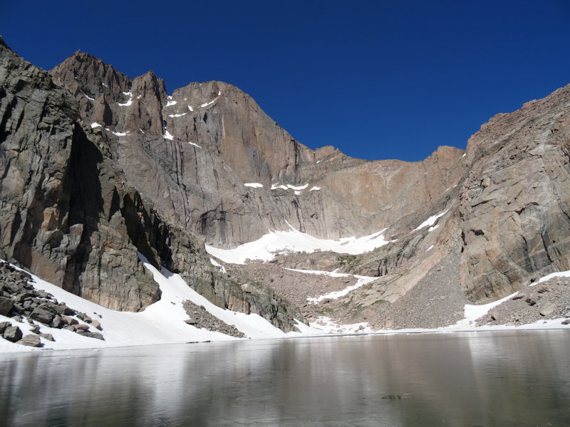 a small lake, overlooked by a craggy mountaintop