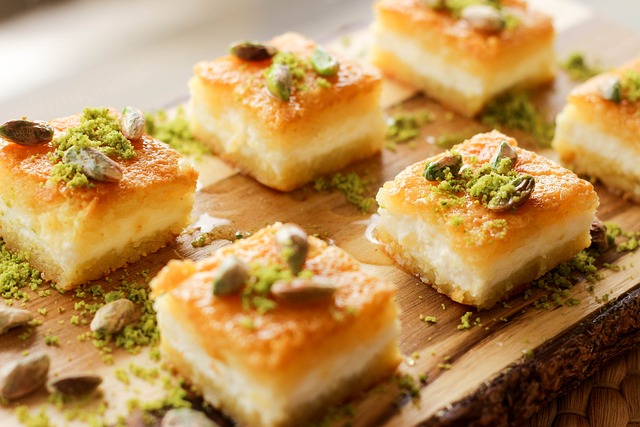 three-layered pastry bars topped with pistachios that are both powdered and whole.